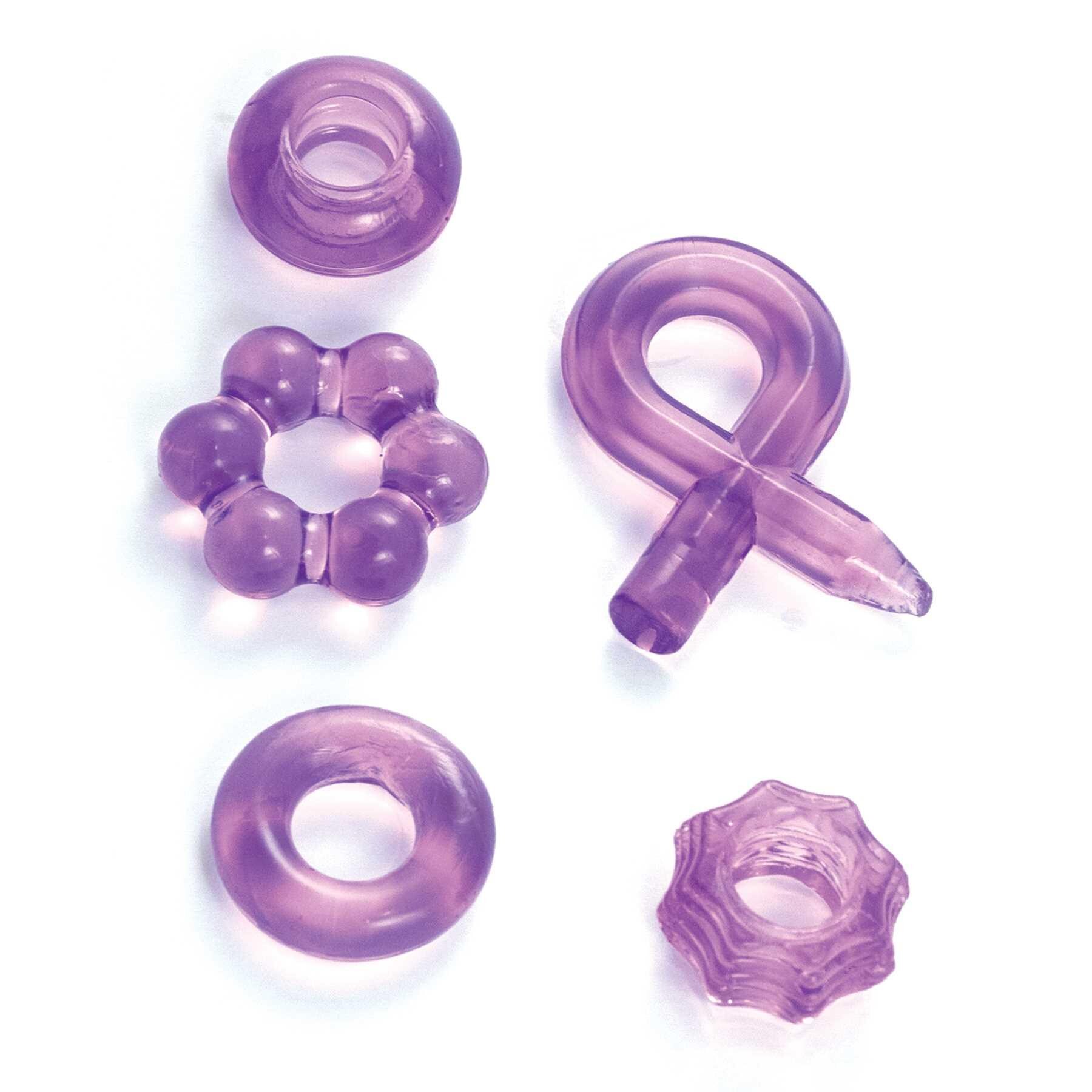 ENHANCER FIVE PIECE COCK RING SET-PURPLE laying on table