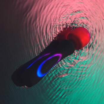 Illumination Wand Massager glowing shown resting in water