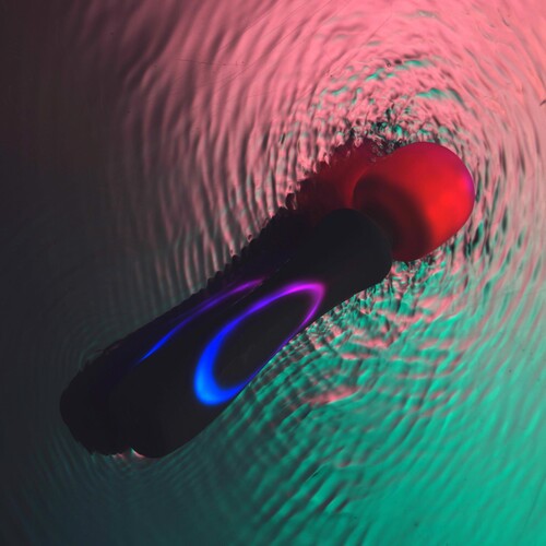 Illumination Wand Massager glowing shown resting in water
