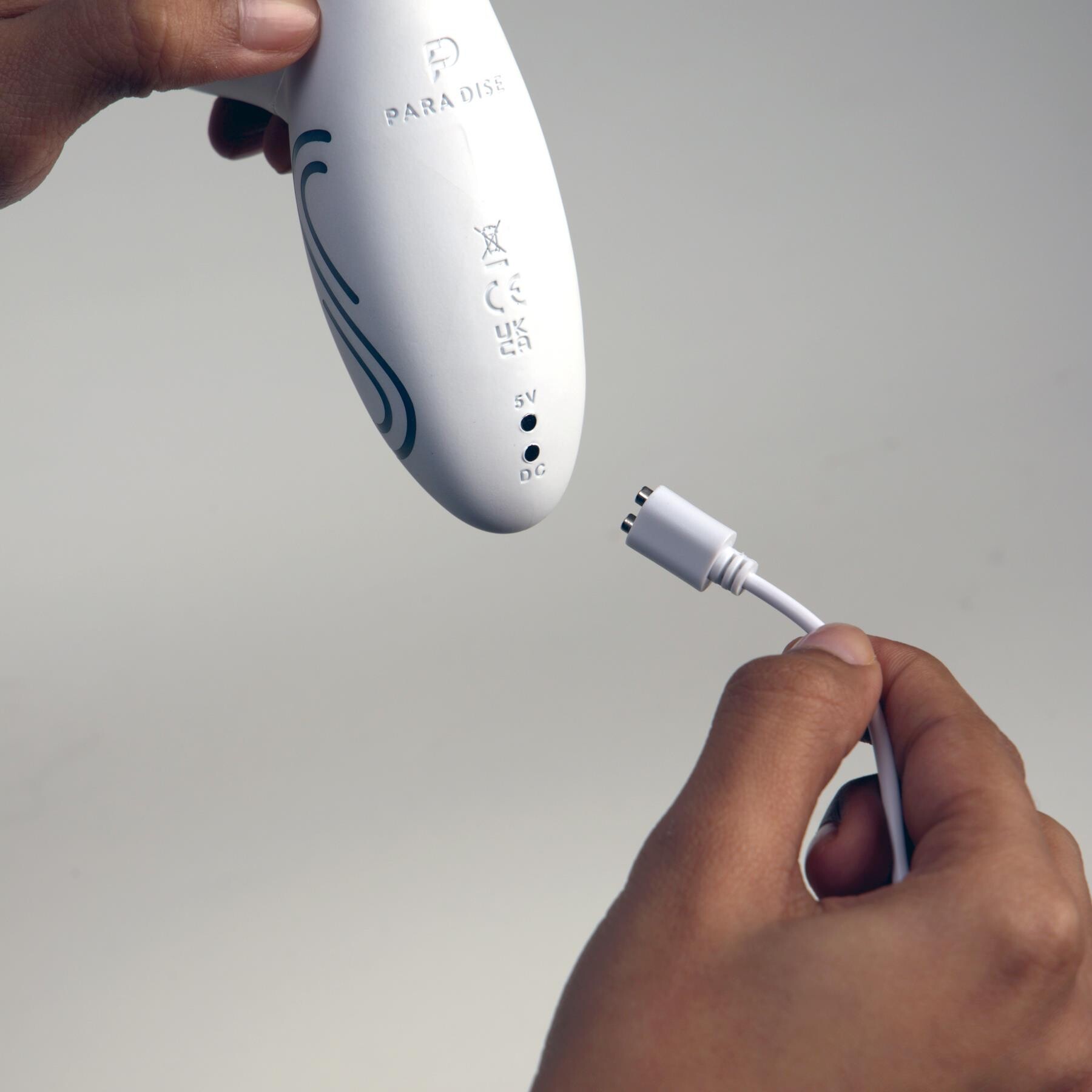 Illumination Rabbit Vibrator showing the charging cable being plugged into the bottom
